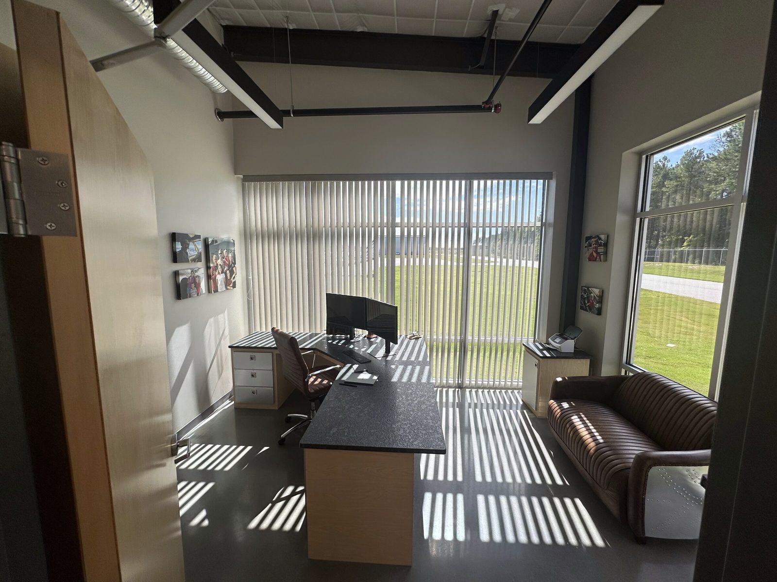 An office with a desk facing the windows and the ramp beyond